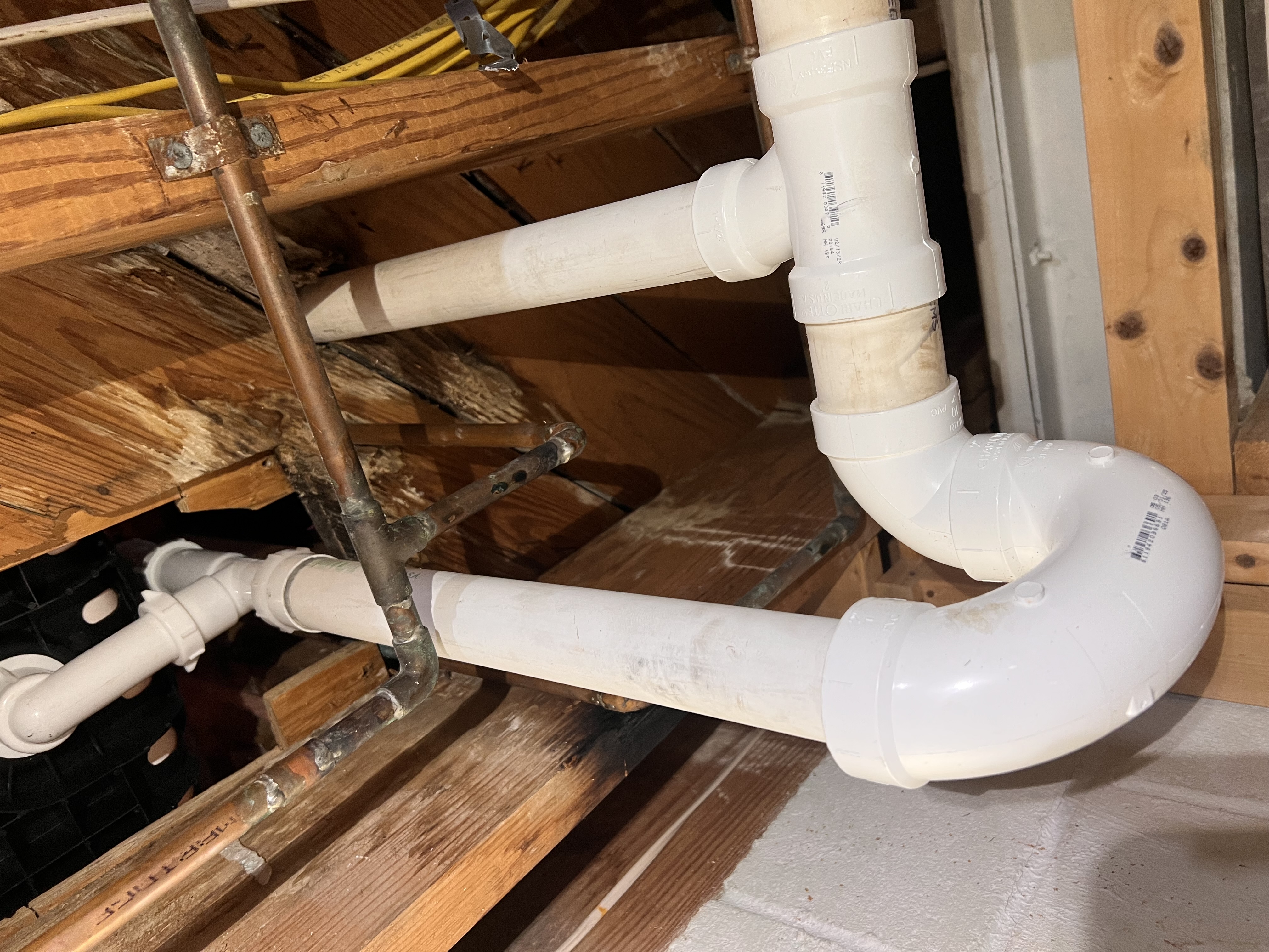 PVC drain piping through floor joists by Ward and Sons Plumbing